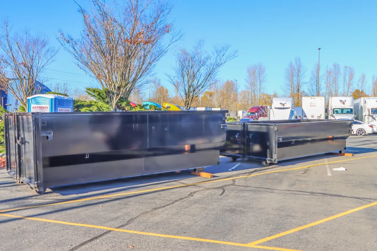 Professional dumpster rental service with roll-off container on residential driveway in Tanaina